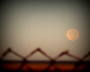 ....Looking at the full moon with the fence in the foreground.